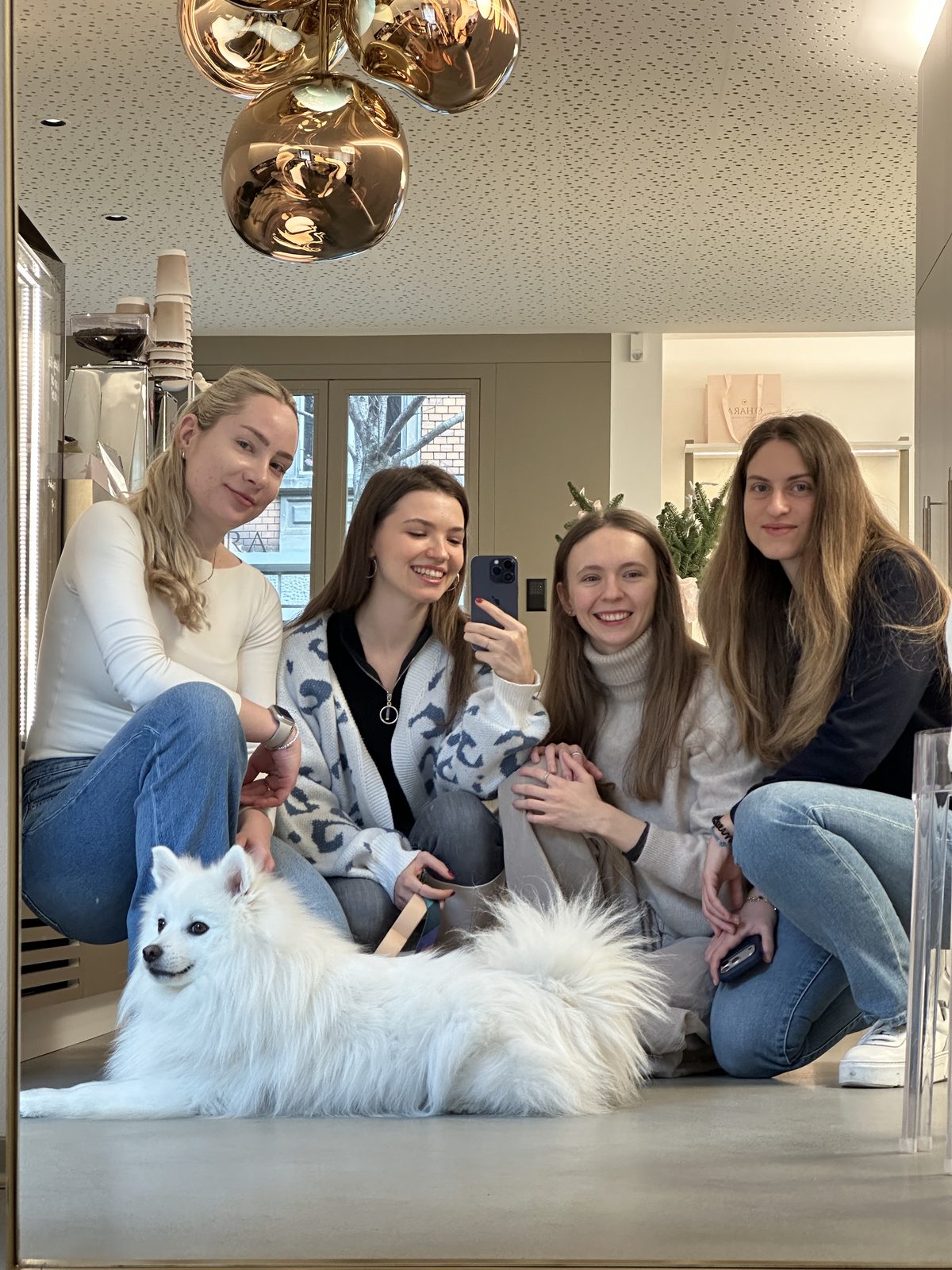 A group of girls with a little white dog
